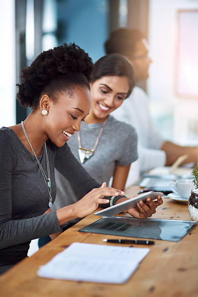 Shot of two young colleagues using a digital tablet together at work