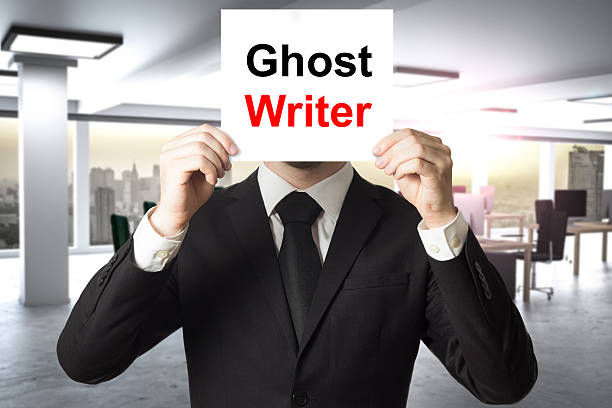 GHOSTWRITER. businessman in black suit hiding face behind sign ghost writer